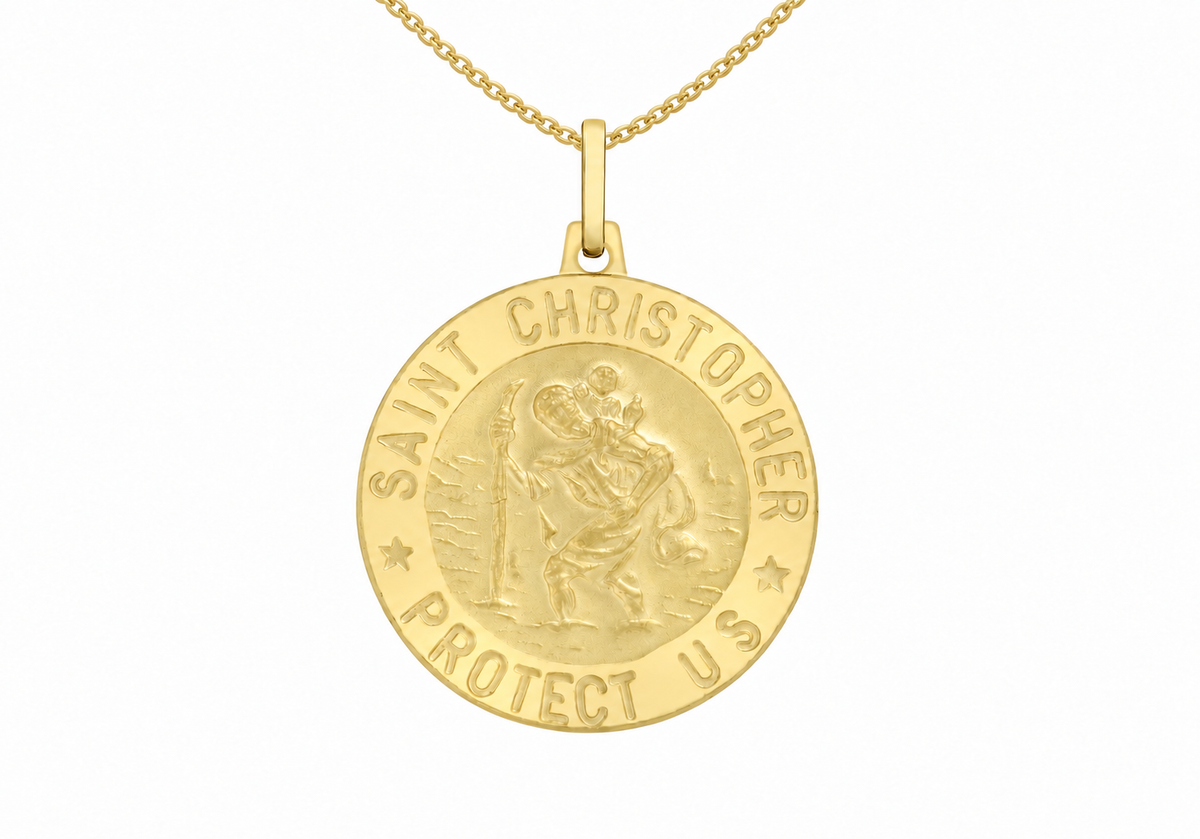 A gold Saint Christopher pendant necklace on a white background. The circular medallion features an embossed depiction of Saint Christopher carrying the Christ Child, with the text 'SAINT CHRISTOPHER PROTECT US' engraved around the border.