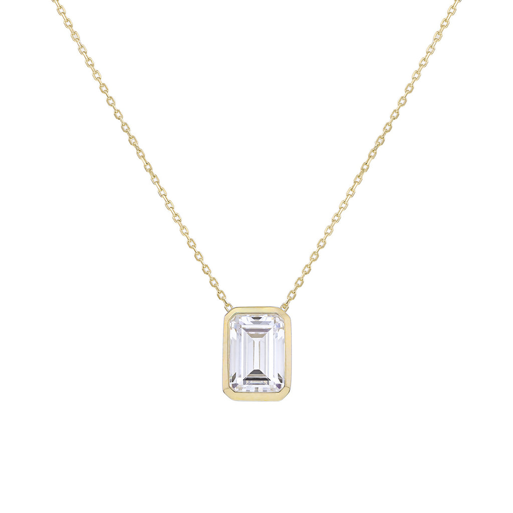 A delicate gold chain necklace featuring a rectangular emerald-cut clear gemstone pendant in a gold bezel setting, shown against a solid white background.