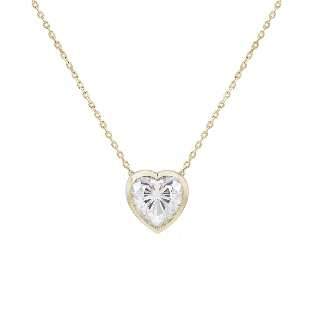 A delicate yellow gold chain necklace with a heart-shaped pendant featuring a clear, faceted heart gemstone in a yellow gold bezel setting, shown against a plain white background.