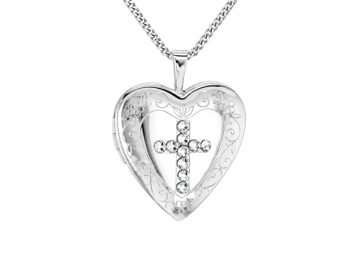 A silver heart-shaped locket pendant necklace with an engraved floral border and a central cross embellished with clear rhinestones, shown on a white background.
