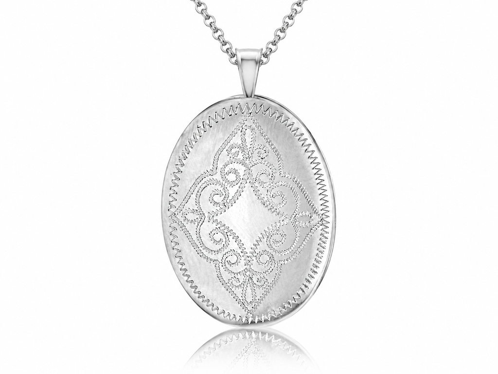 A silver oval locket pendant necklace with an engraved floral scroll pattern and a beaded border, suspended from a matching silver chain against a white background.